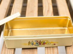 Vintage tin box with elegant figures and golden interior, perfect for storing keepsakes or treats.