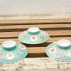 Antique Chinese turquoise porcelain plates with vibrant floral designs and red symbols.