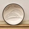 Artistic cream ceramic bowl with nature-inspired design and bird motifs, perfect for decor.