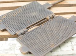 Antique cast iron waffle maker showcasing rustic charm and timeless culinary tradition.