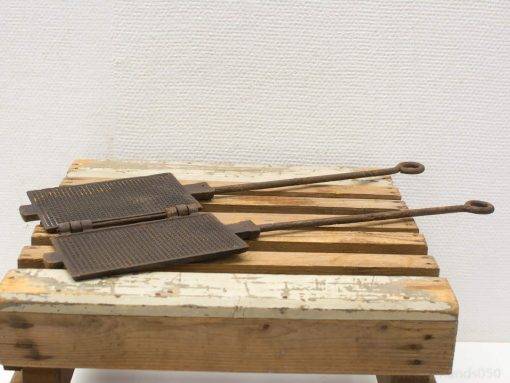 Vintage cast iron waffle irons on rustic wood, perfect for traditional waffle making.