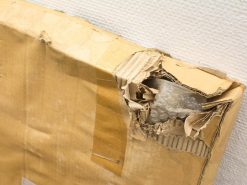 Damaged cardboard box revealing bubble wrap, highlighting concerns for fragile items during shipping.
