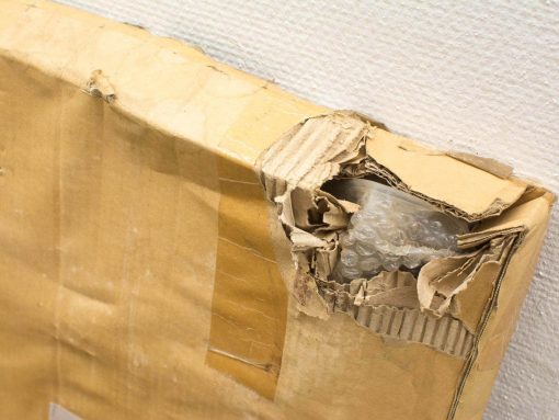 Damaged cardboard box revealing bubble wrap, highlighting concerns for fragile items during shipping.