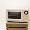 Sleek Sharp microwave with elegant gold trim, perfect for small kitchens and quick meals.