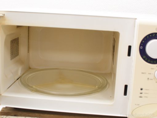 Compact white microwave featuring a transparent turntable and user-friendly controls for easy cooking.