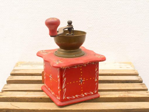 Charming vintage red coffee grinder with hand-painted designs, perfect for any kitchen decor.