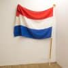 Vibrant Dutch flag with tricolor design, showcasing red, white, and blue against a clean backdrop.