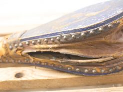 Vintage wooden artifact with intricate detailing, rich blue patina, and history of craftsmanship.