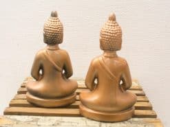 Serene Buddha statues on rustic wooden base, perfect for creating a peaceful ambiance.