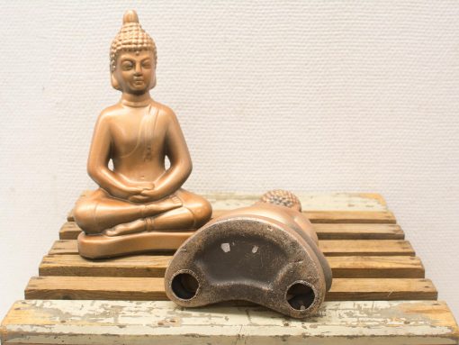 Serene bronze Buddha statue on rustic wood, symbolizing tranquility and spiritual depth.
