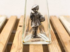 Vintage silver boy figurine under glass cloche, capturing charm and nostalgia for collectors.