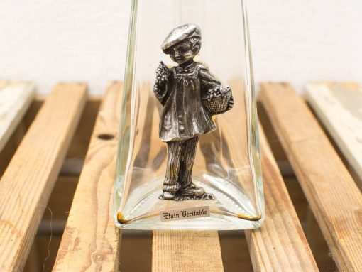 Vintage silver boy figurine under glass cloche, capturing charm and nostalgia for collectors.