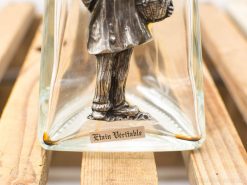 Vintage glass display piece with intricate pewter figurine of a man in elegant attire.
