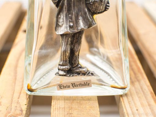 Vintage glass display piece with intricate pewter figurine of a man in elegant attire.