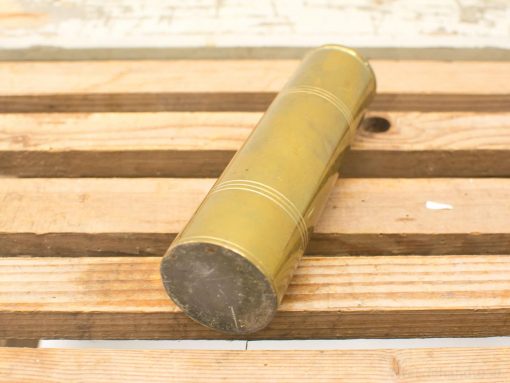 Shiny vintage brass cylinder on rustic wood, perfect decorative accent for any space.