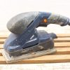 Used electric power sander for woodworking on vintage wood pallets, ideal for craftsman projects.