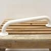 Rustic wooden platform with white grab bar for safety in bathrooms or workshops.