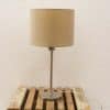 Modern vintage table lamp with sleek metallic base and cozy fabric shade on rustic wood.