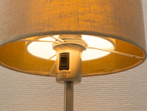 Elegant vintage lamp with a metal base and warm fabric shade, enhancing any decor.