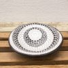 Elegant black and white ceramic plate with intricate patterns, perfect for decor or serving.