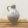 Elegant gray ceramic jug with blue floral design, perfect for décor or functional use.