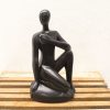 Minimalist seated figure sculpture exuding serenity and contemplation for modern art enthusiasts.