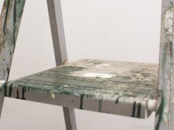 Vintage metal step ladder with paint splatters, perfect for creative DIY projects.