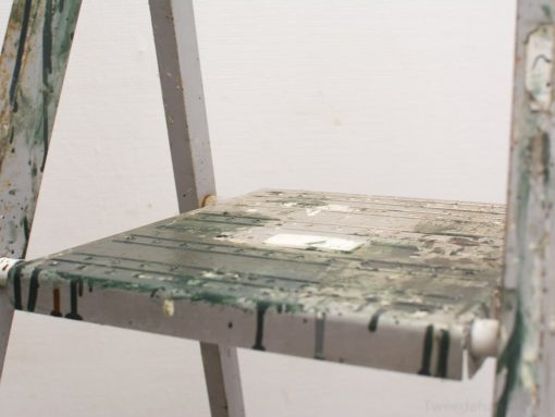 Vintage metal step ladder with paint splatters, perfect for creative DIY projects.