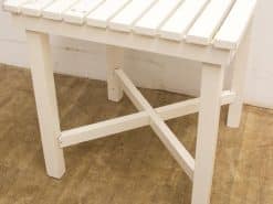 Stylish white wooden table with slatted design and sturdy legs, perfect for any setting.