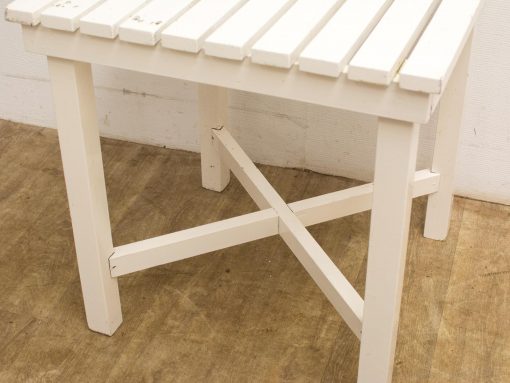 Stylish white wooden table with slatted design and sturdy legs, perfect for any setting.