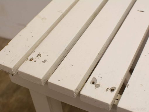 Stylish white wooden table with character, perfect for dining or crafting in any space.