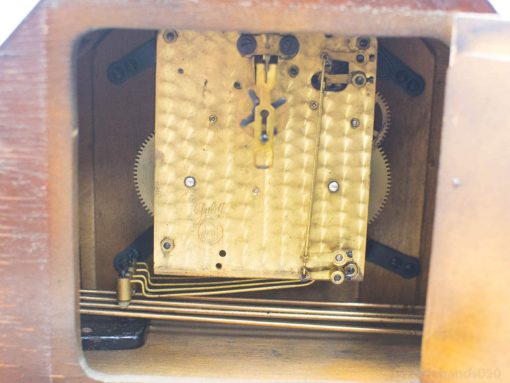 Antique music box with intricate brass mechanism and warm wooden casing, perfect for collectors.