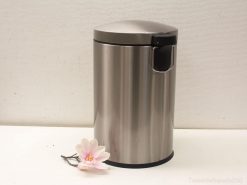 Sleek stainless steel trash can with pink flower accent for modern home decor.