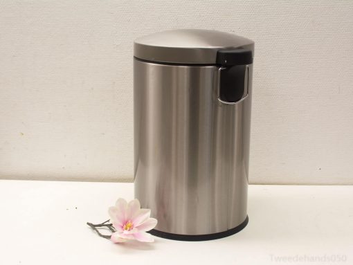 Sleek stainless steel trash can with pink flower accent for modern home decor.