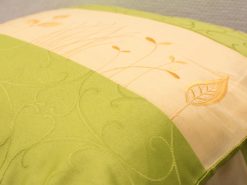 Elegant green and beige decorative pillow with nature-inspired embroidery for stylish home decor.