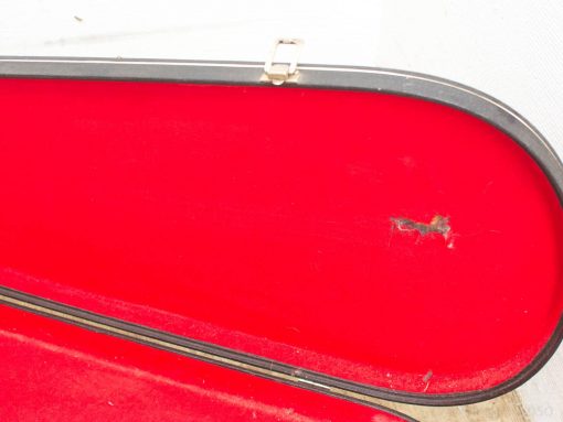 Elegant musical instrument case with red velvet lining, showcasing character and history.