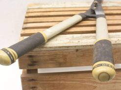 Vintage garden loppers on a rustic crate, ideal for pruning and maintaining your garden.