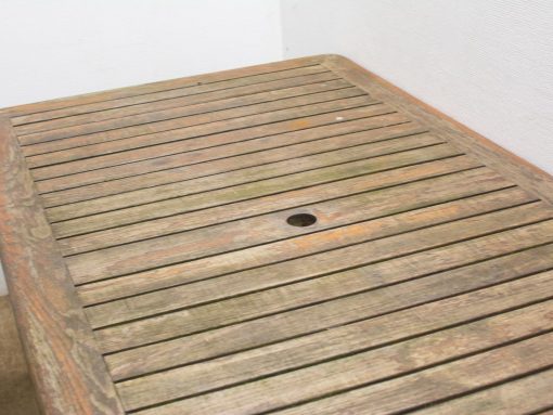 Rustic wooden outdoor table with umbrella hole, perfect for gardens and patios.