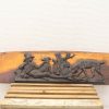 Wooden plaque depicting a shepherd with dogs, celebrating pastoral life and natures beauty.
