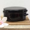 Elegant black casserole dish with lid and magnolia flower, perfect for cooking and serving.