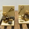 Adorable teddy bears, one reading and one playing sports, on a rustic wooden base.