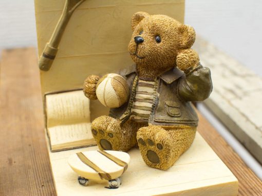 Charming teddy bear with sports accessories, perfect for nostalgic decor and playful collections.