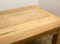 Rustic wooden dining table with natural finish, sturdy legs, and minimalist design.