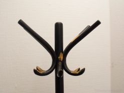 Sleek black vintage coat rack combines minimalist design with charming signs of use.