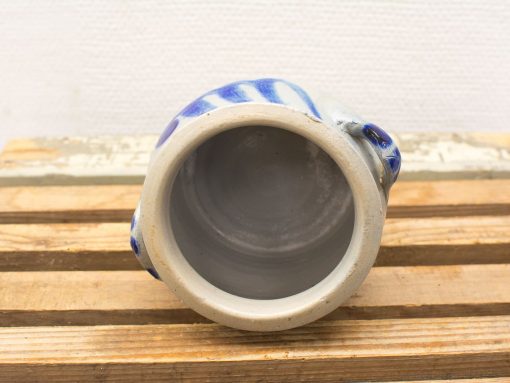 Handmade gray ceramic mug with vibrant blue designs, perfect for everyday use or decoration.