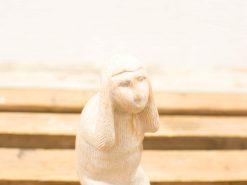 Charming stone sculpture of a whimsical humanoid with curious expression and artistic detail.