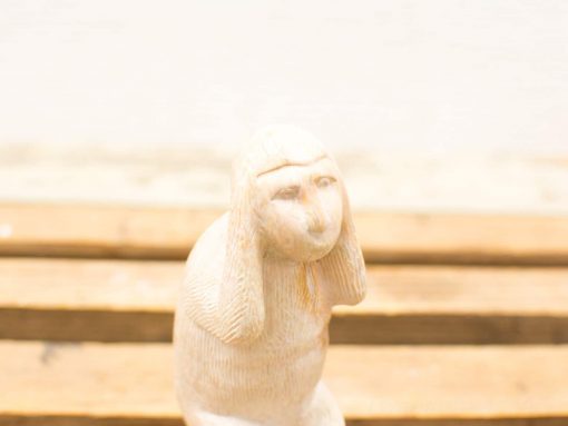 Charming stone sculpture of a whimsical humanoid with curious expression and artistic detail.