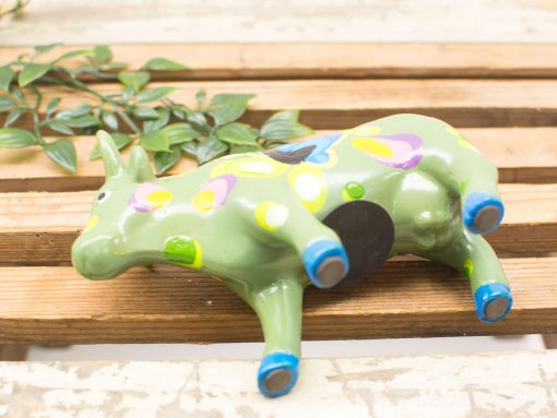 Vibrant green ceramic cow figurine with colorful patterns for charming home or garden decor.