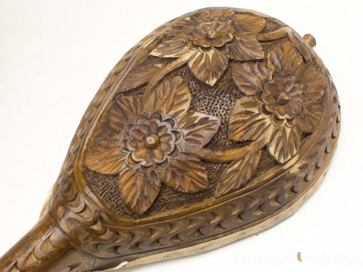 Elegant carved wooden decoration with floral motifs in a warm, rich tone.