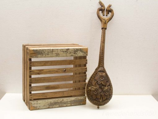 Rustic wooden crate and intricately crafted string instrument, showcasing functionality and artistic heritage.